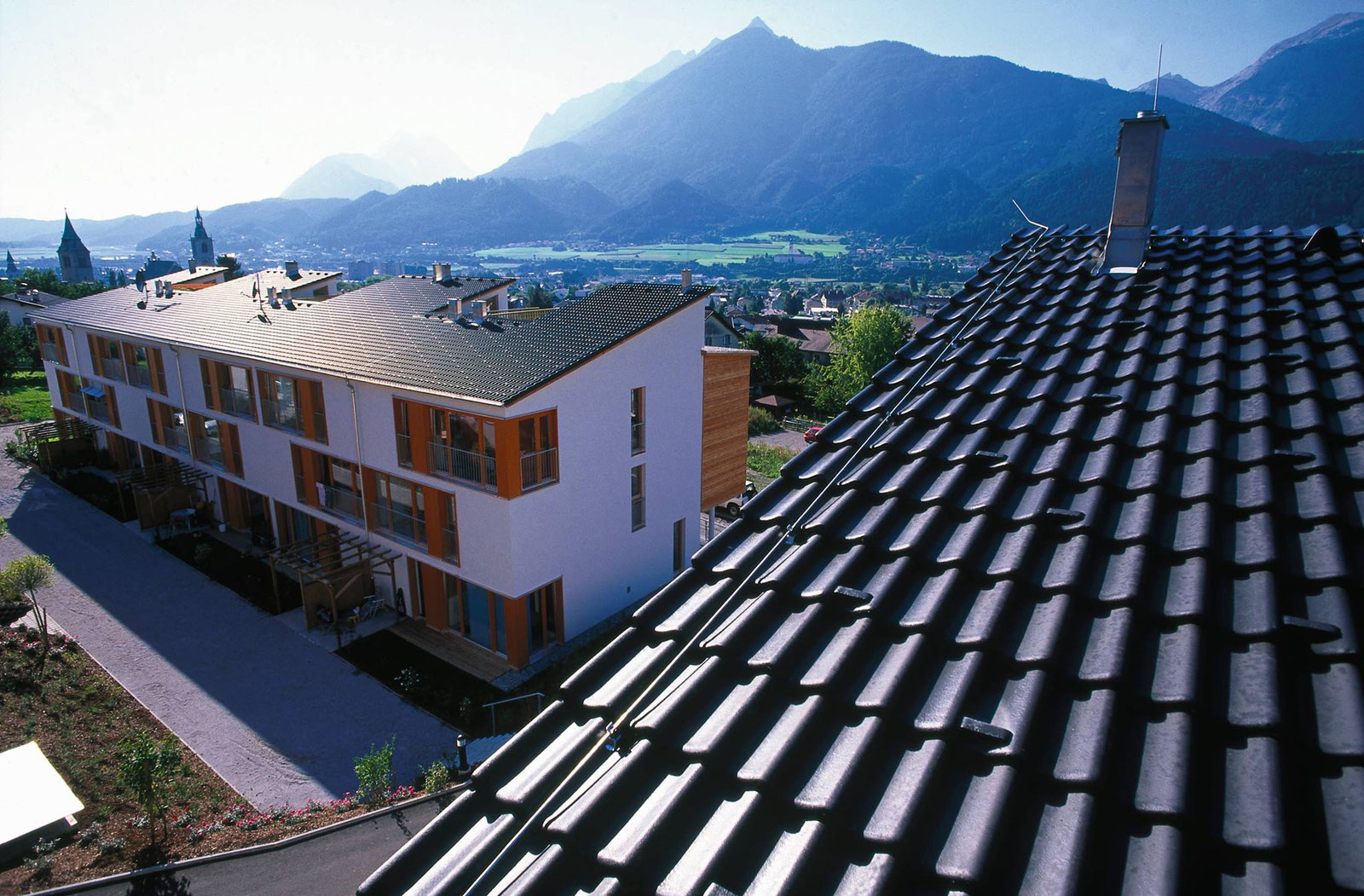 Weites, dunkel gedecktes Dach über dem Inntal bei Wattens, dahinter die Tiroler Berge